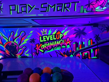 Neon bowling alley with "LEVELUP KORAMANGALA" graffiti and bowling balls.