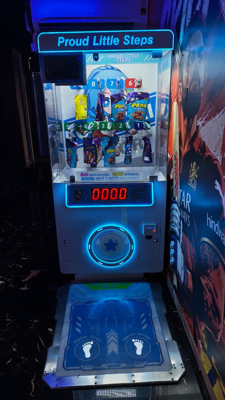 A claw machine game called "Proud Little Steps" with candy prizes and a dance pad in a dimly lit arcade.