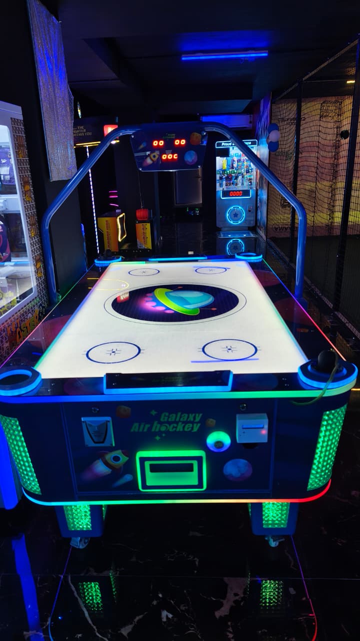 An air hockey table with colorful lights in an arcade.