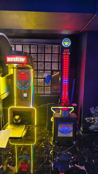 Two arcade games, a "Boxer & Kicker" and a "Hammer King," are lit up in a dimly lit entertainment venue.