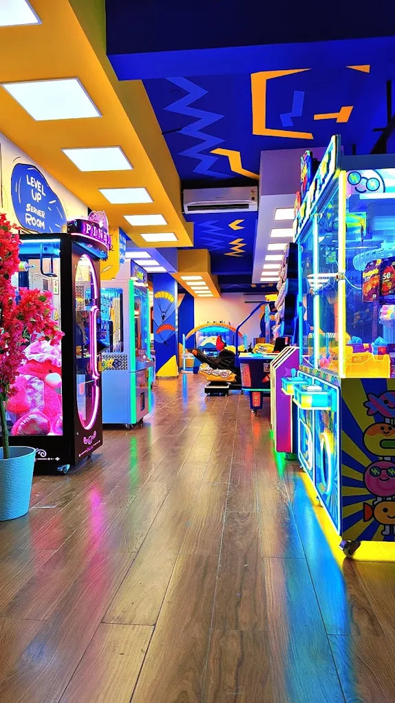 An arcade with colorful lights and games, featuring a wooden floor and a bright, energetic atmosphere.