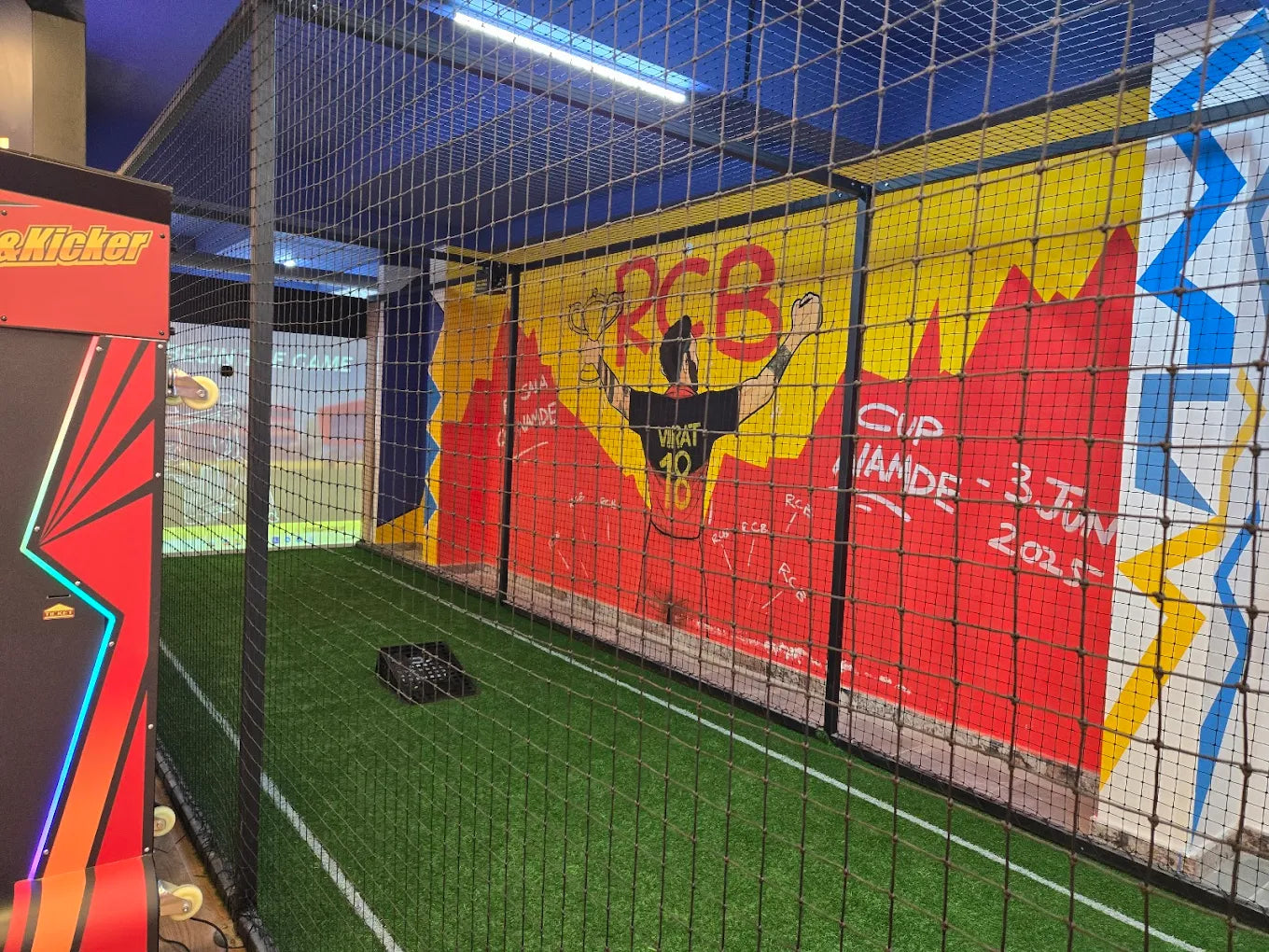 A sports batting cage with a mural of a cricket player and a date.