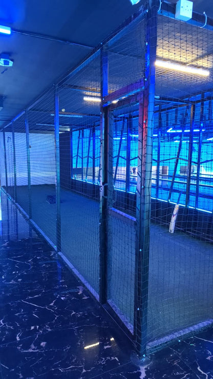 Indoor cricket net with blue lighting and a cricket bat.