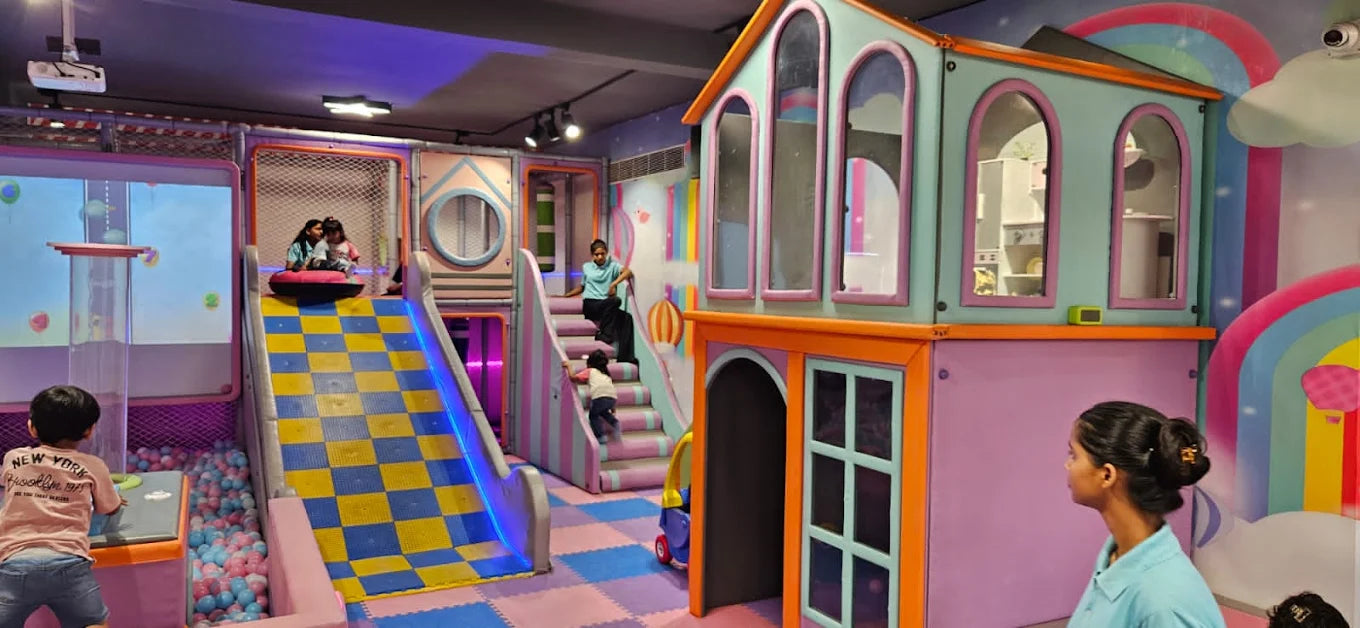 Children play in a colorful indoor playground with slides, ball pits, and a playhouse.