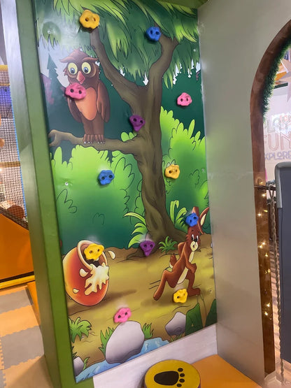A colorful climbing wall with cartoon animals for children to play on.