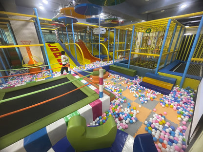 A children's indoor playground with ball pits, slides, and trampolines.