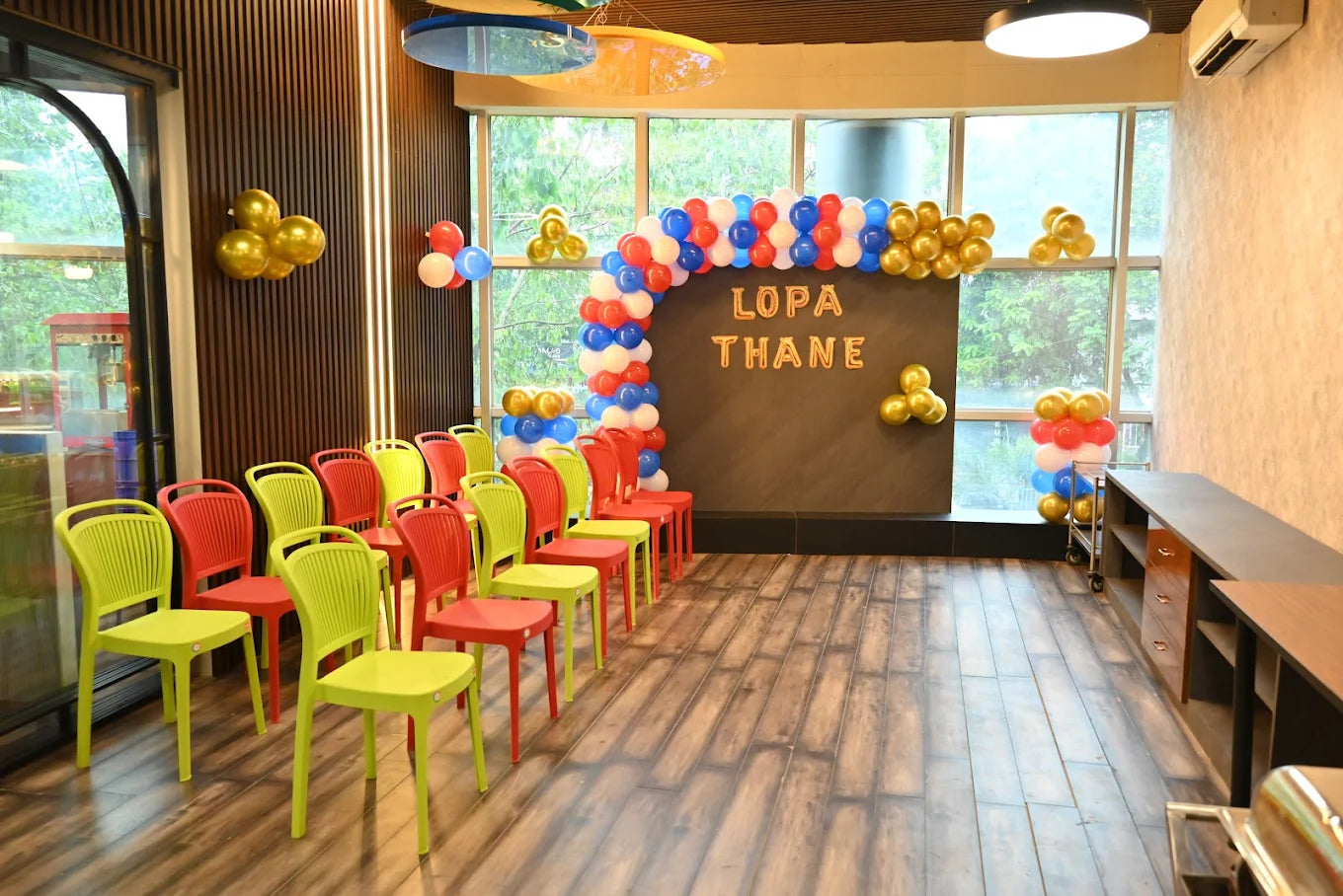Chairs arranged for an event with balloons and a "LOPA THANE" banner.