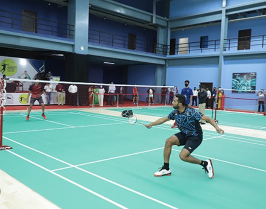 Badminton player in action on a court with spectators in the background