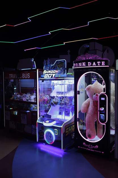 Arcade claw machines with prizes and neon lights.