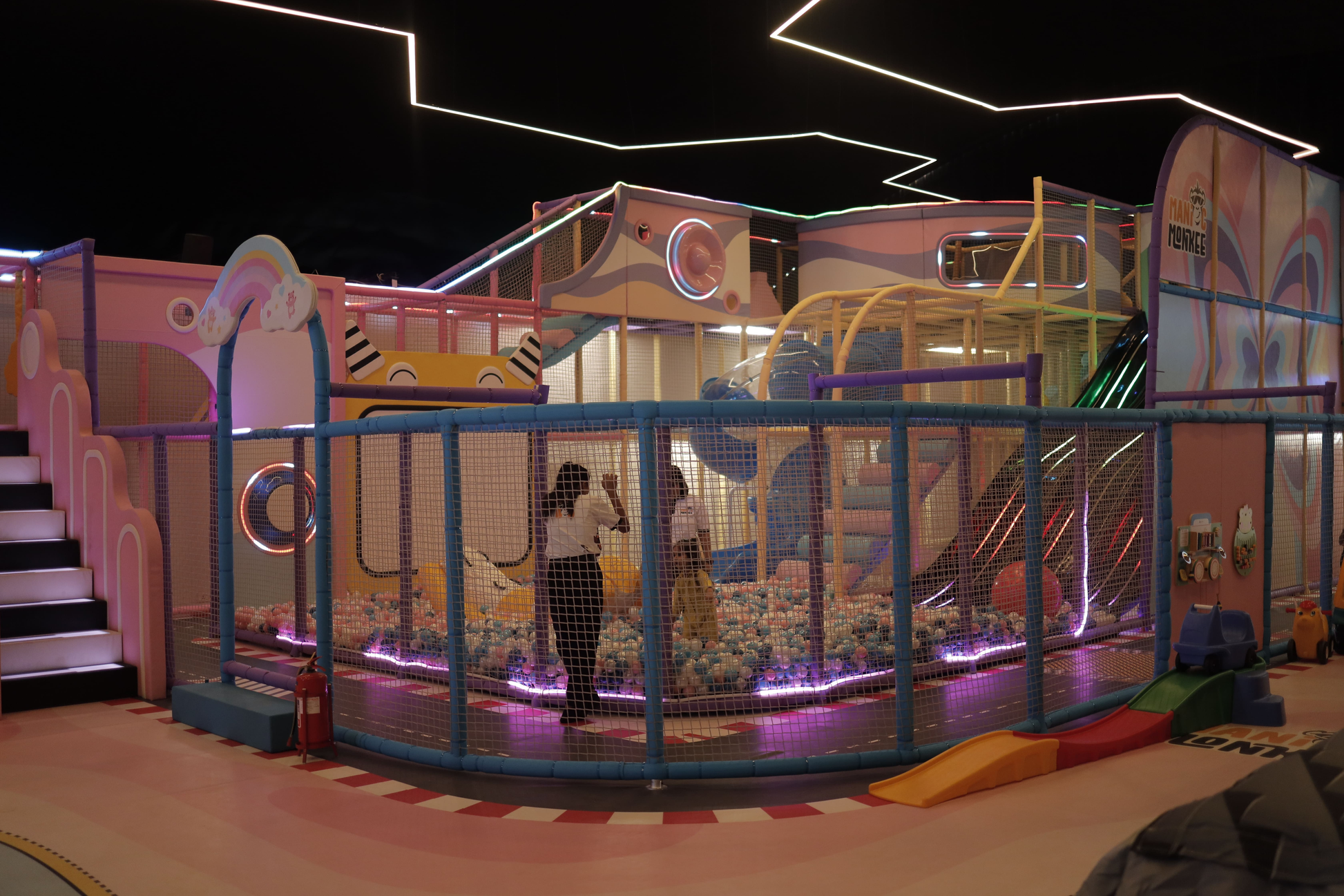 A colorful indoor playground with a ball pit and slides, where children can play.