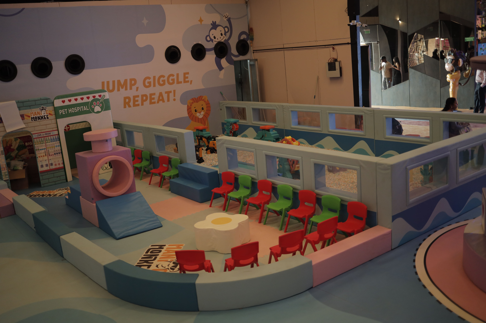 A colorful indoor playground with soft play structures and seating for children.