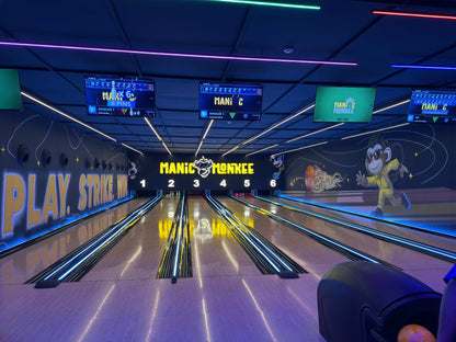 A bowling alley with neon lights and a "Manic Monkey" theme, showing multiple lanes and scoreboards.