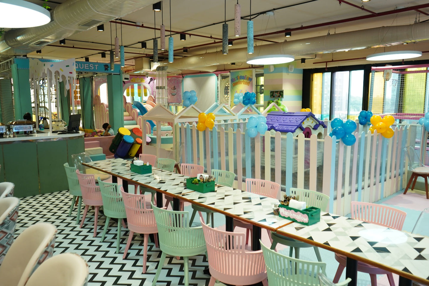 A brightly colored indoor playground with tables and chairs set up for dining.