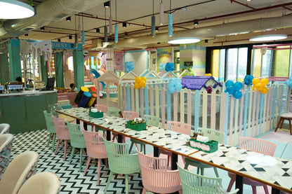 A brightly colored indoor playground with tables and chairs set up for dining.
