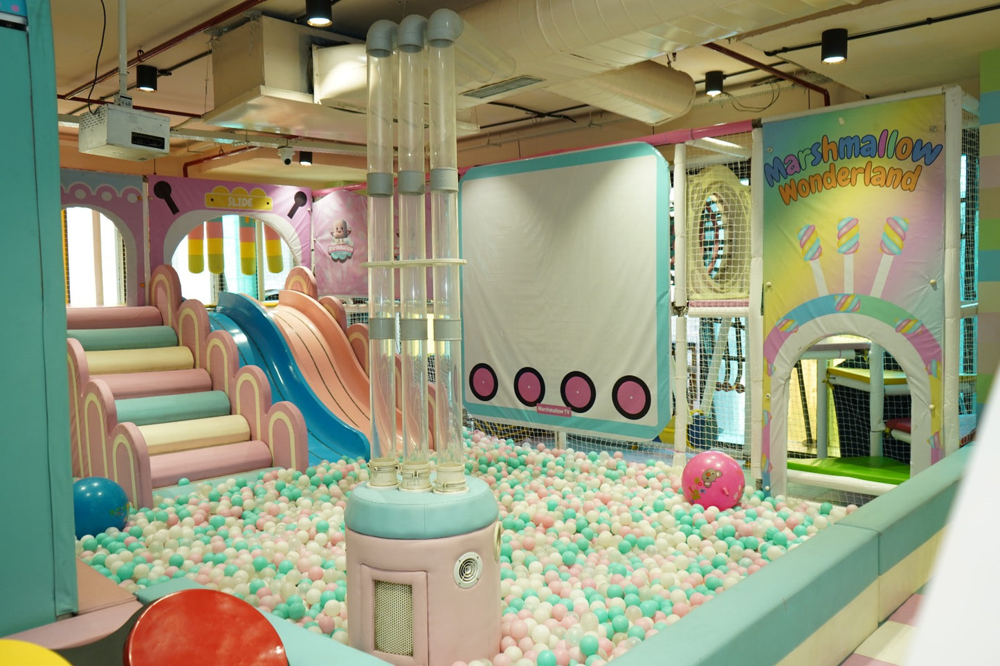 A colorful indoor playground with a ball pit, slides, and climbing structures for children.