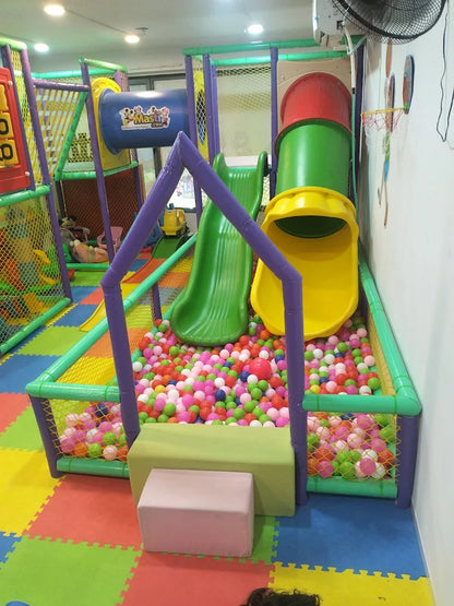 A colorful indoor playground with slides, a ball pit, and climbing structures for young children.