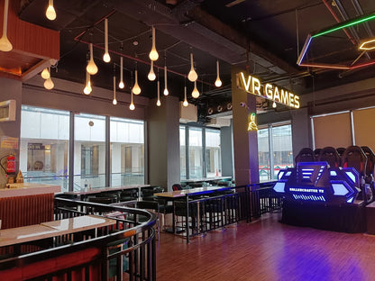 Modern restaurant interior with 'VR Games' sign and gaming setup.
