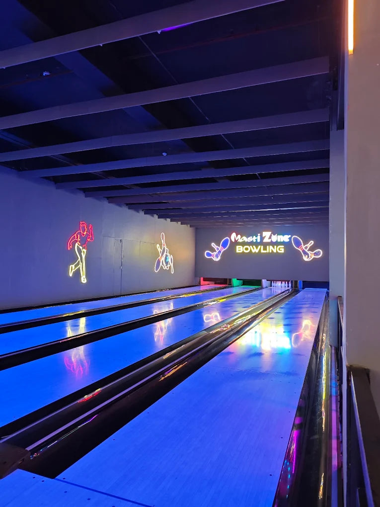 Neon lights illuminate bowling lanes at Masti Zone.
