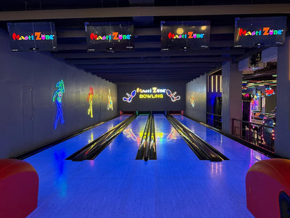 A bowling alley with neon lights and arcade games.