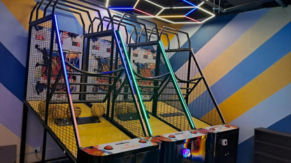 Arcade basketball game with colorful lights and a striped wall.