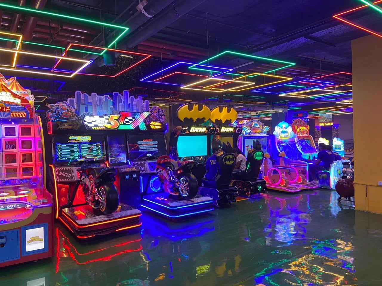 Colorful arcade room with various games and neon lights.