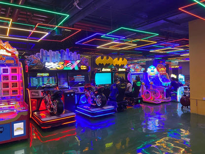 Colorful arcade room with various games and neon lights.