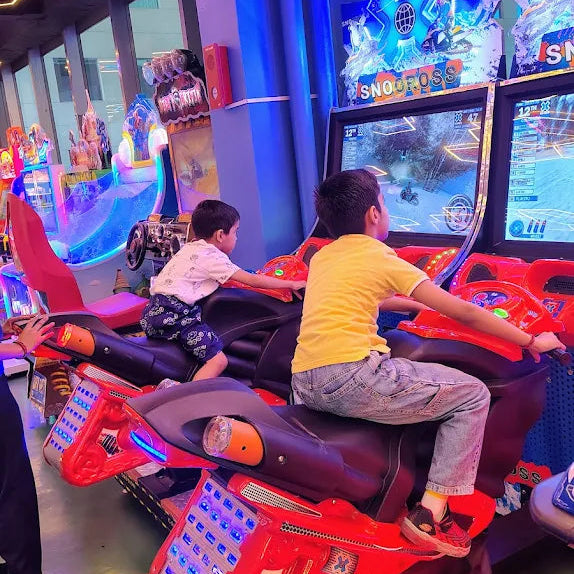 Children playing in an arcade with colorful lights and gaming machines.