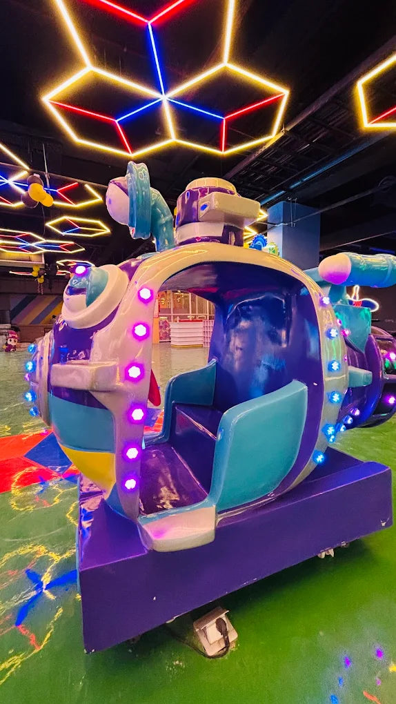 Colorful amusement park ride with neon lights on a green floor