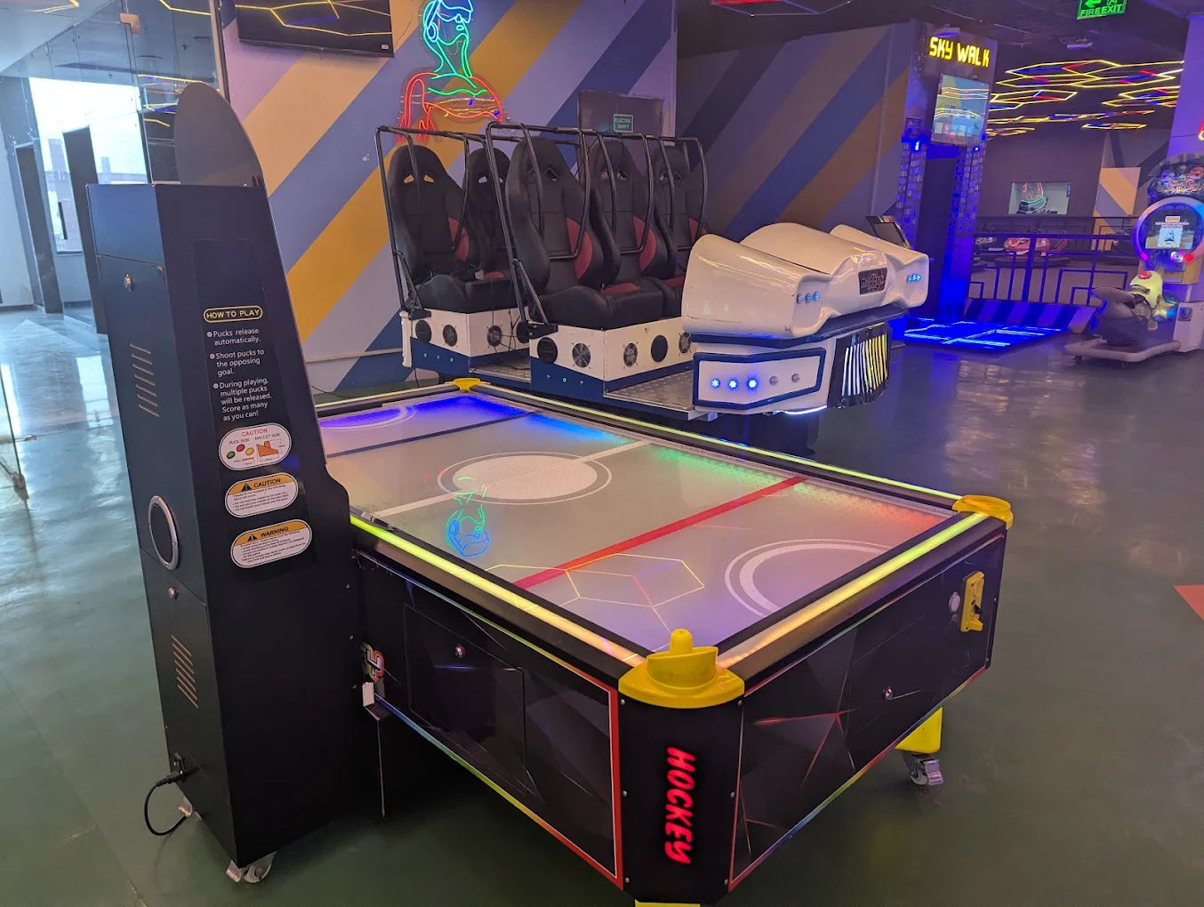 Air hockey table in an indoor recreational area with colorful walls and flooring.