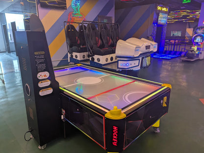 Air hockey table in an indoor recreational area with colorful walls and flooring.