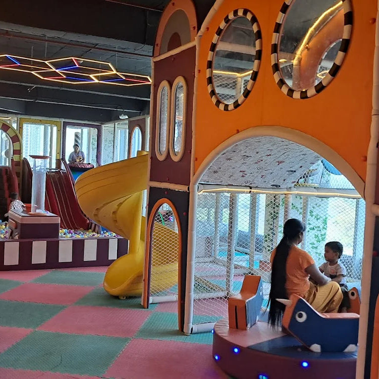 Children's play area with colorful slides and structures in a mall.
