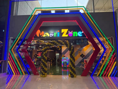 Entrance to Masti Zone, a brightly lit arcade with neon lights and balloon arches, likely for children.