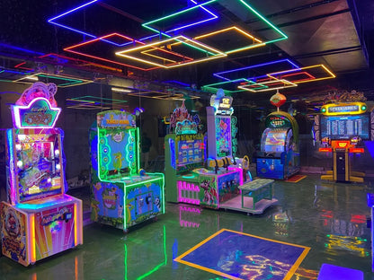 An arcade with colorful neon lights and various video games.