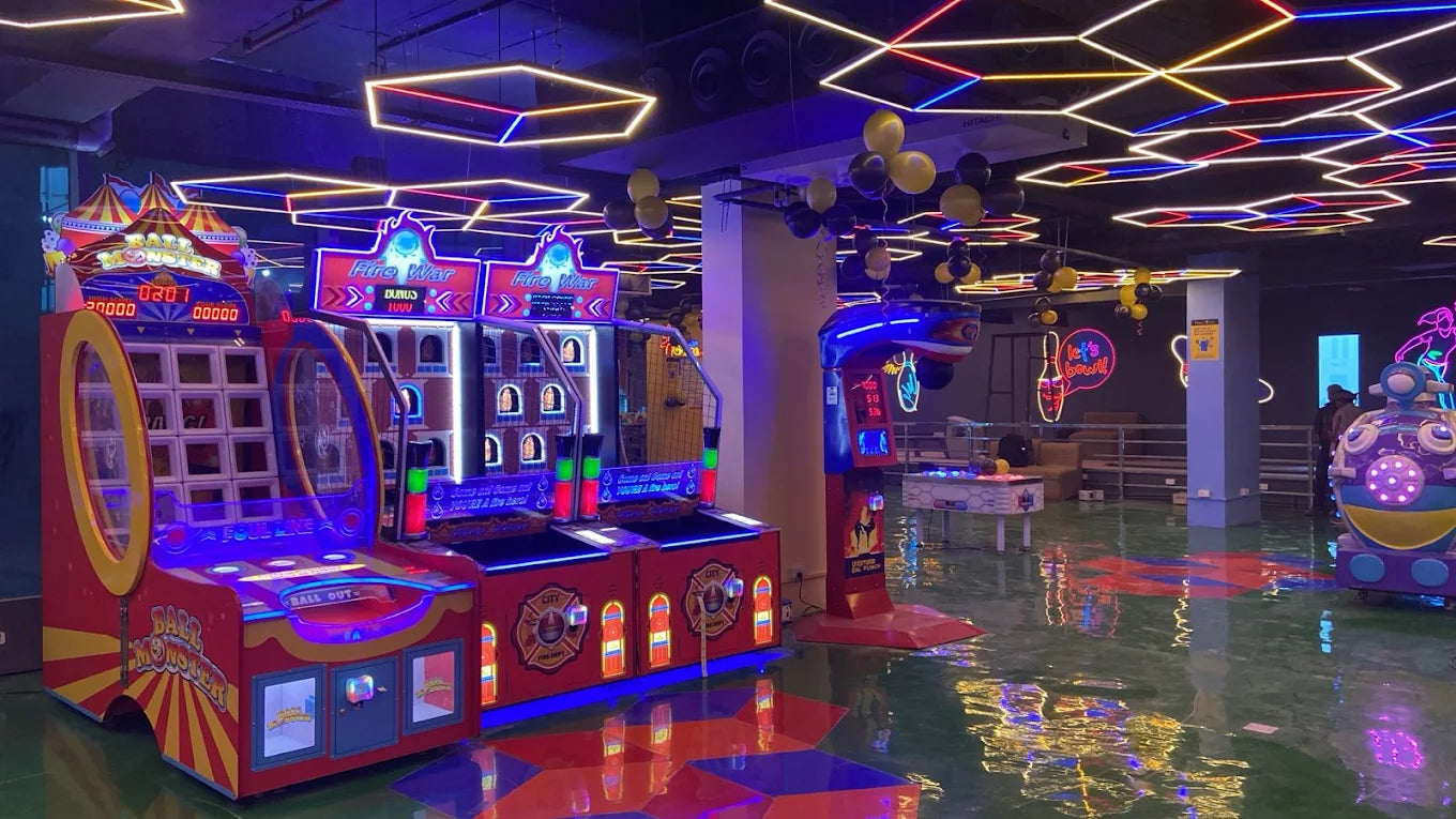 An arcade with colorful lights and games, including a "Ball Monster" and "Fire War" machine.