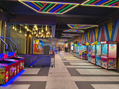 Arcade game center with colorful flooring and various game machines.