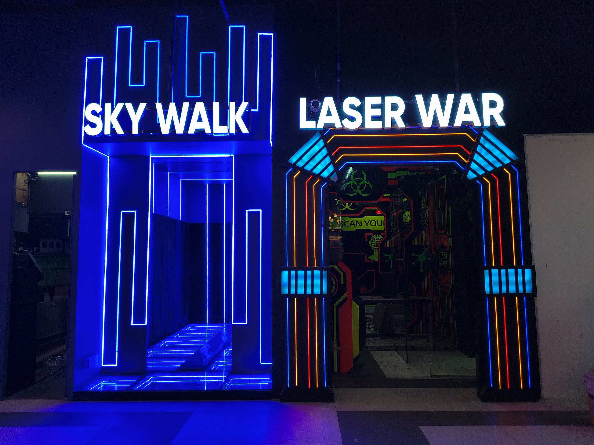 Neon-lit entrances to "Sky Walk" and "Laser War" attractions.