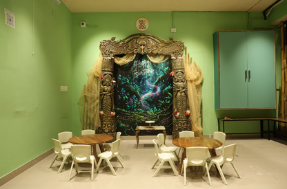 Children's party setup with a jungle-themed backdrop, tables, and chairs.