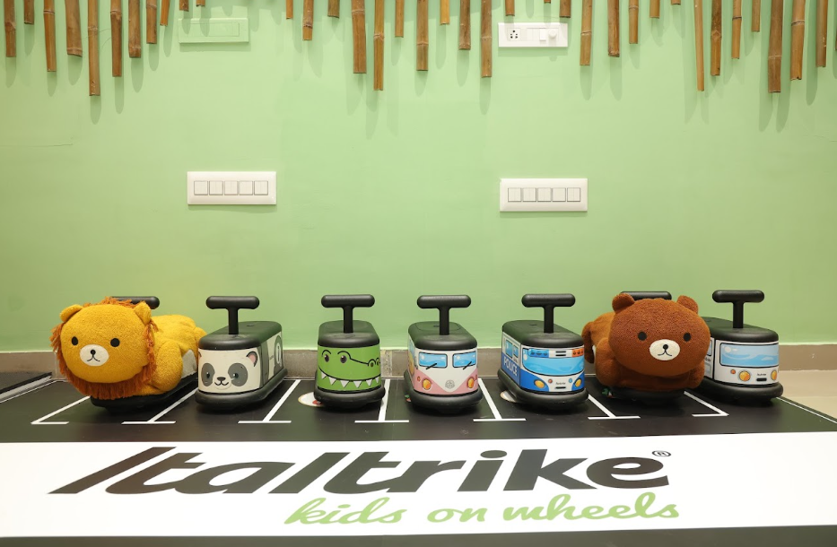 Children's ride-on toys shaped like animals and vehicles are lined up on a play mat.