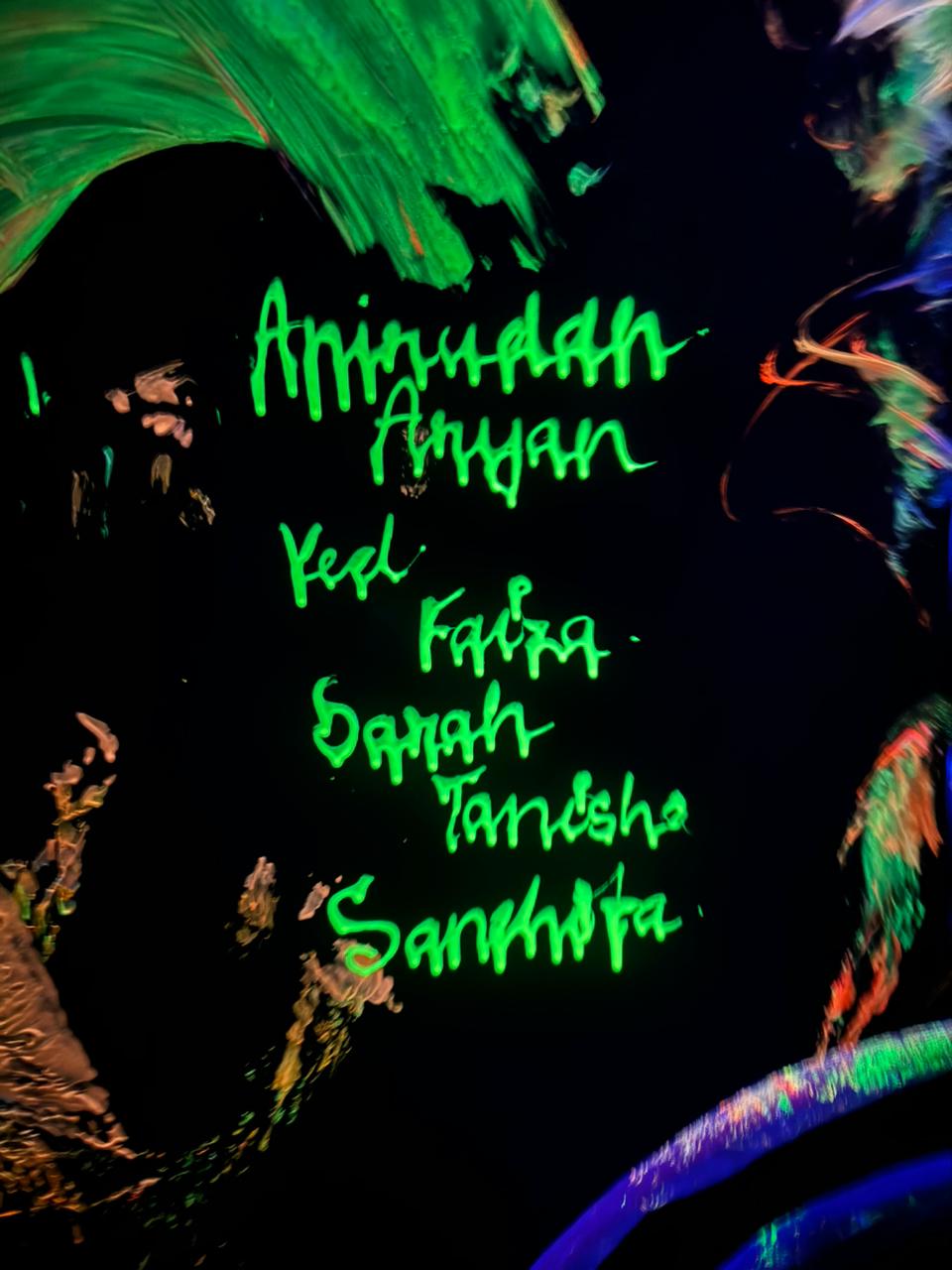 Neon green names are written on a black background with abstract colorful paint strokes.