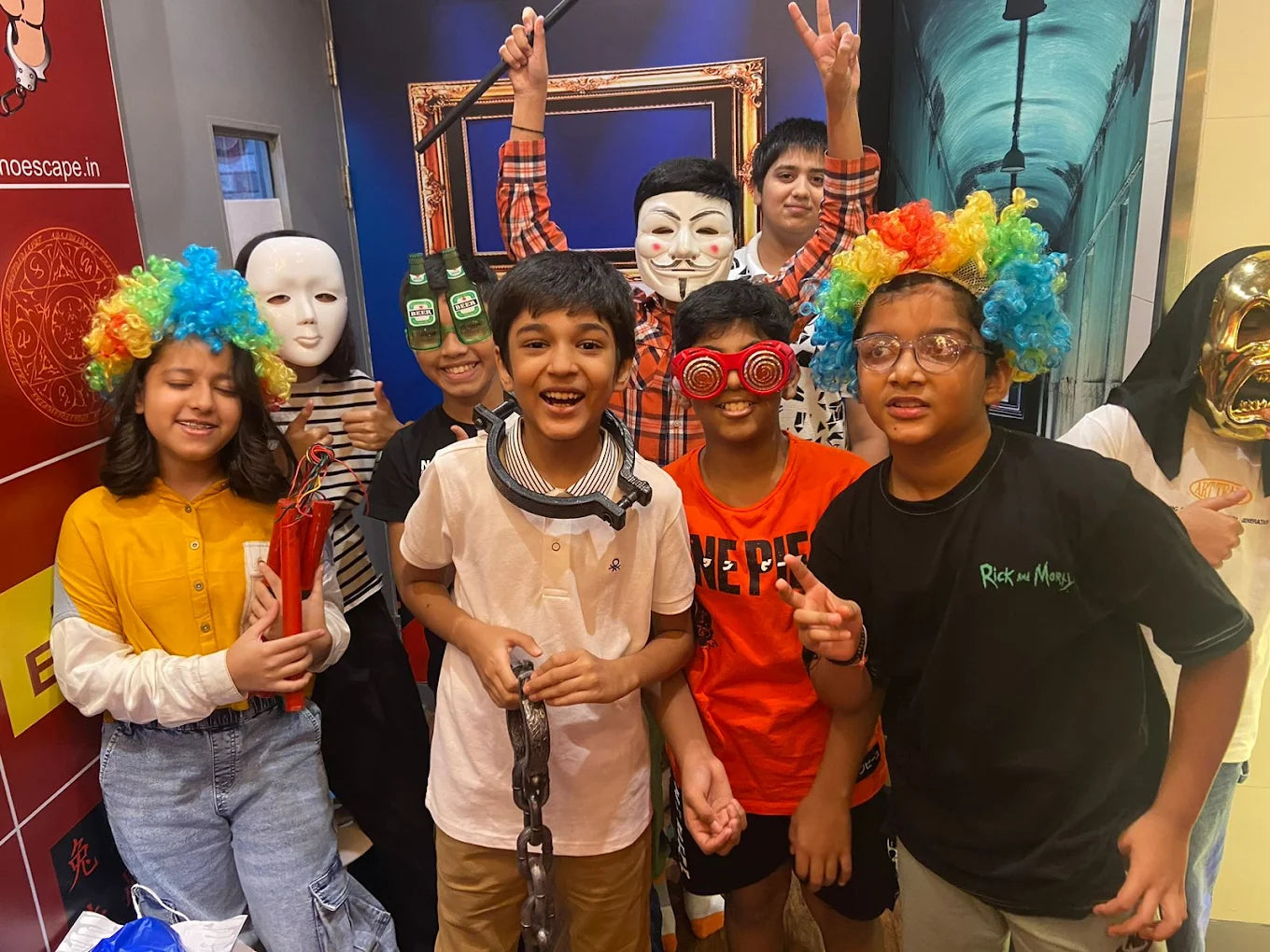 A group of children in costumes and masks pose for a photo, possibly at an escape room.