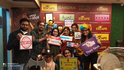 A group of young adults poses for a photo at an escape room, holding signs with humorous messages.