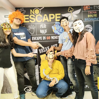 A group of young adults poses for a photo in front of a "No Escape" themed wall, some wearing masks and one holding a toy gun.