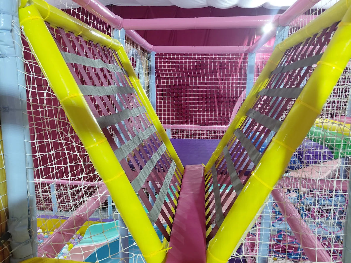 A colorful indoor playground with soft padding and nets, designed for children's play.