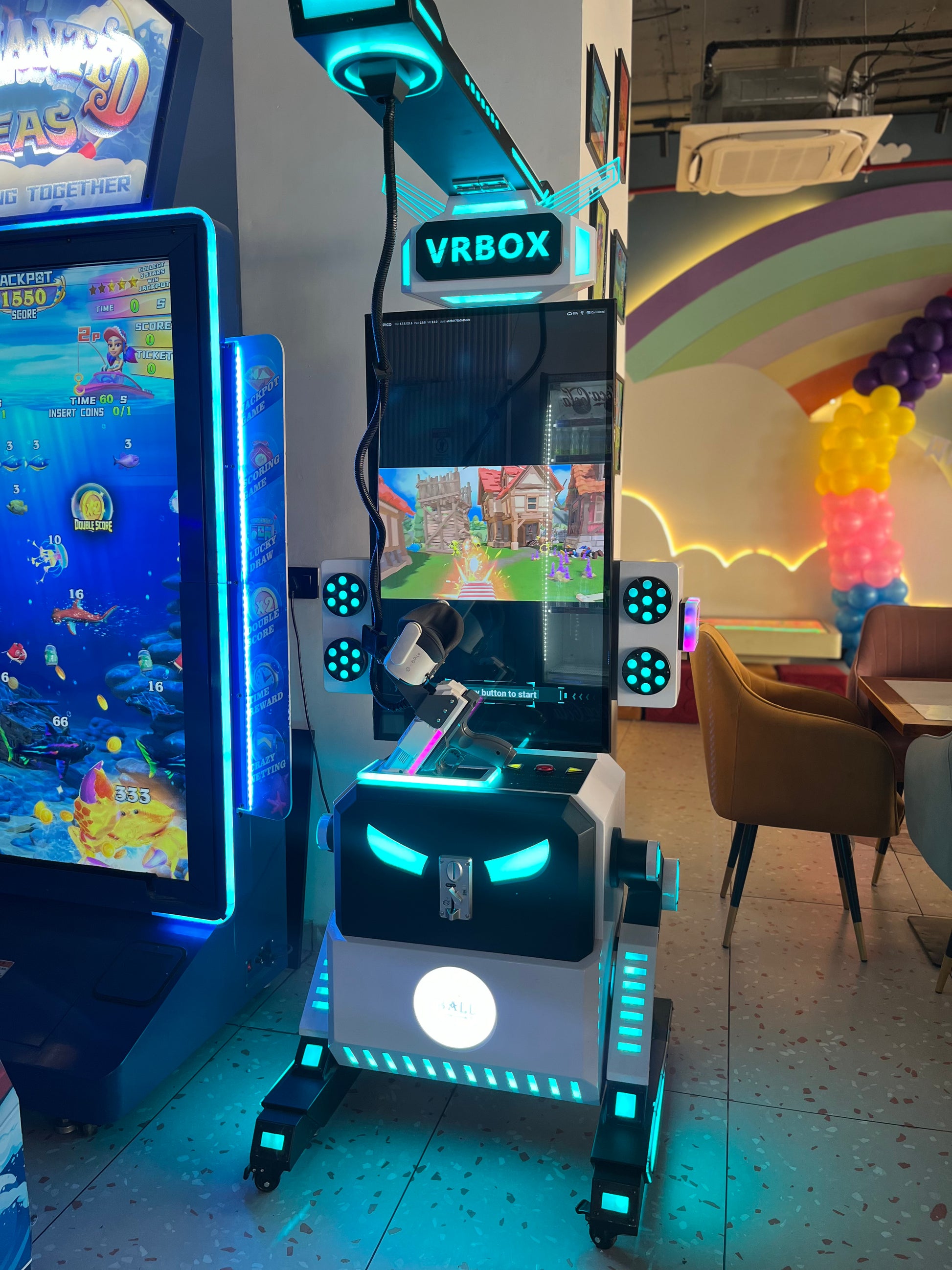 A VR arcade game with a robot-like console and a fishing game machine, illuminated by neon lights.