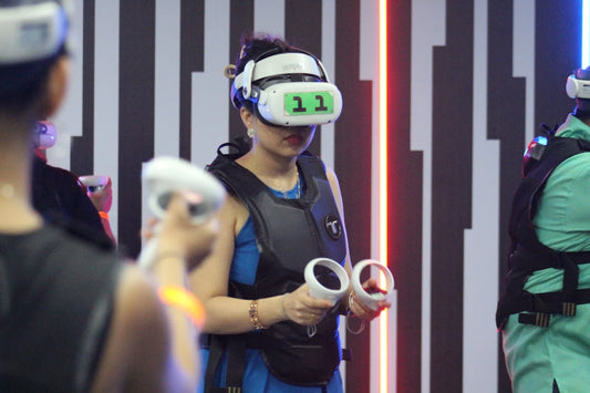 People in a virtual reality arcade wearing VR headsets and holding controllers.