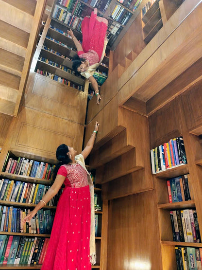 Two women in a library with bookshelves that appear to be upside down.