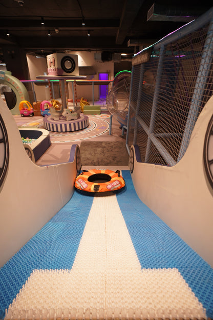 Children's play area with a blue and white striped floor, toy cars, and a small playground structure.