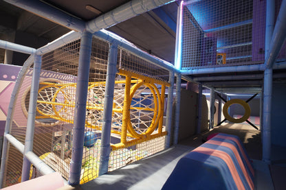 Children's indoor play area with colorful structures and slides.