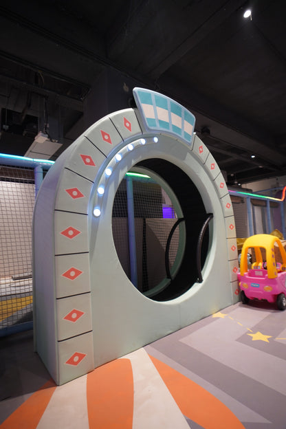 Children's play area with a colorful slide and toys on a dark floor.