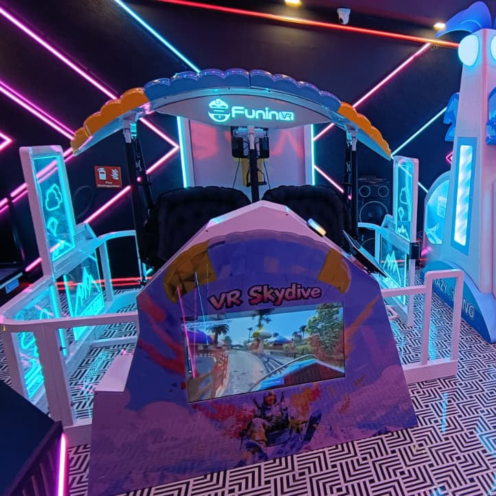 A VR skydive simulator with neon lights and a patterned floor.